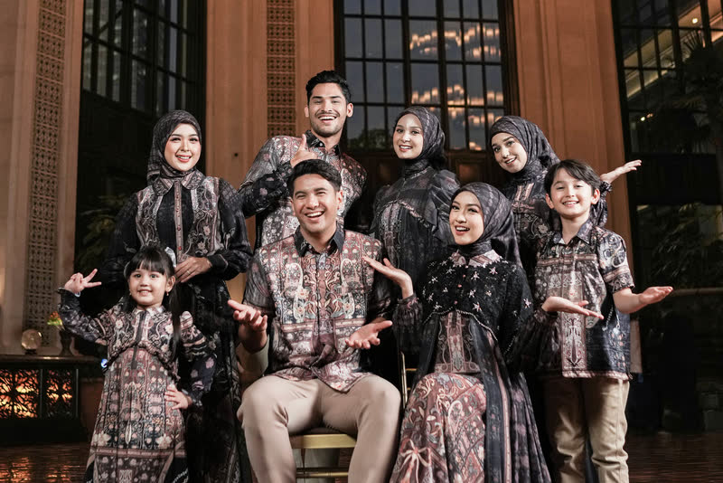 A family wearing Book of Life in Eternal, beneath candle chandeliers